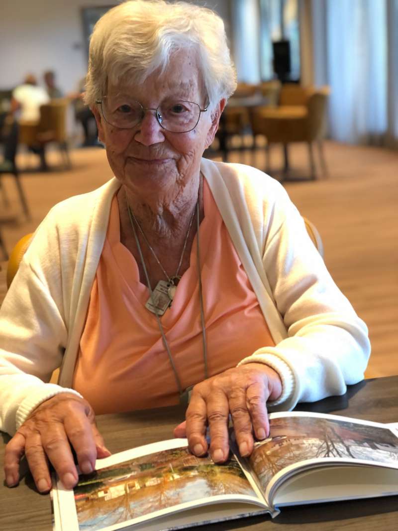 Mevrouw Peters-Gerritsen bekijkt haar fotoalbum van haar oude huis